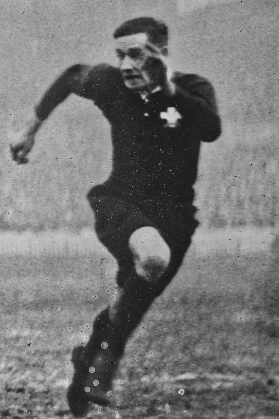 Joueur lancé à pleine vitesse à Twickenham en 1926 : maillot à col, short de toile ample mi-cuisse, chaussettes hautes.
